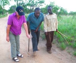 Lisa, David and Jacob (left to right) study tracks on our bushwalk near Kikoti. 